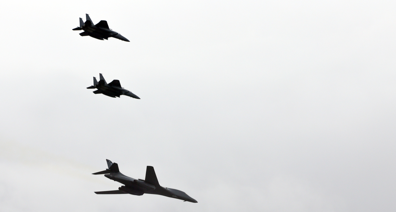 A US Air Force B-1B Lancer supersonic strategic bomber (bottom) makes its first appearance at the Armed Forces Day ceremony, flying under the escort of South Korean F-15K jets at Seoul Air Base in Seongnam, Gyeonggi Province, Tuesday. (Presidential office via Yonhap)