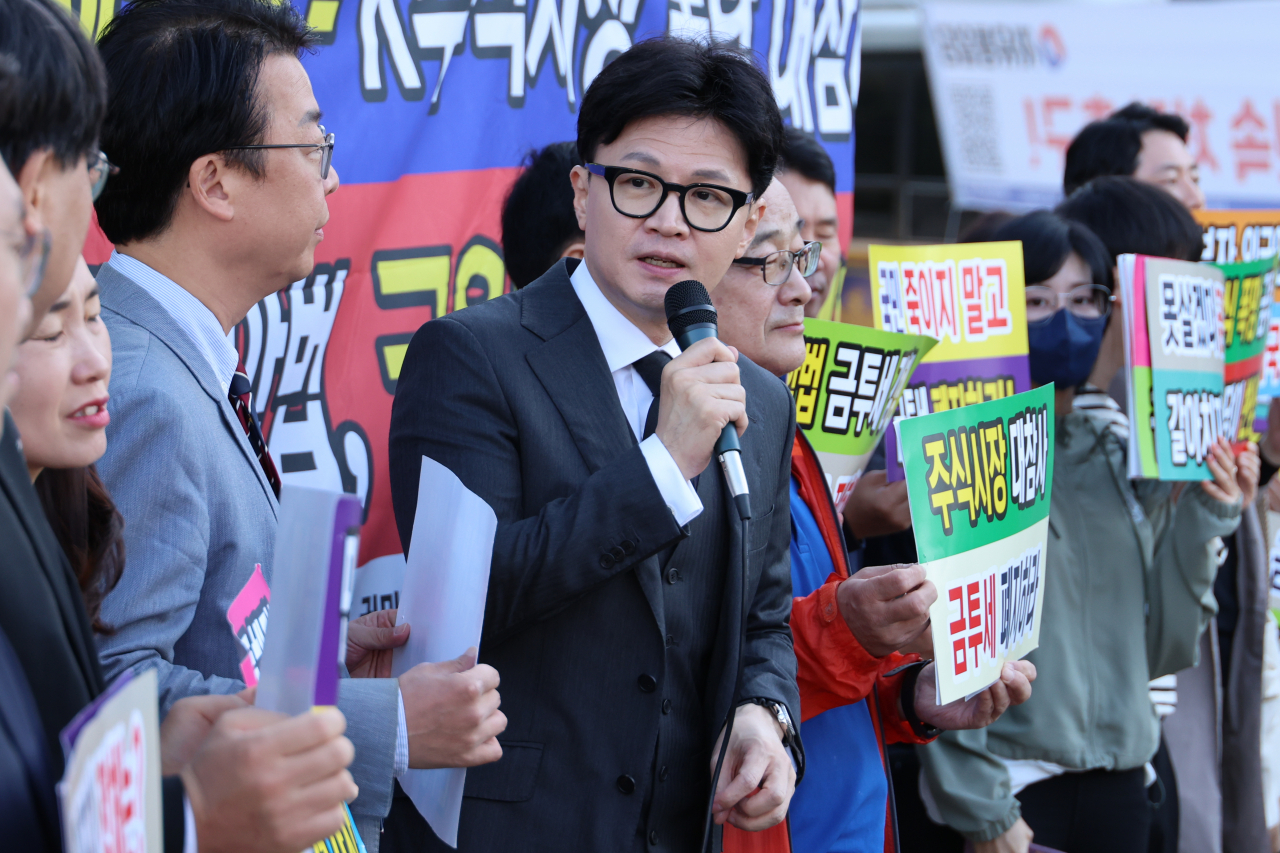 People Power Party Chair Han Dong-hoon, center, joins a rally organized by by the Korea Stockholders Alliance, held in front of the National Assembly in western Seoul on Friday. (Yonhap)