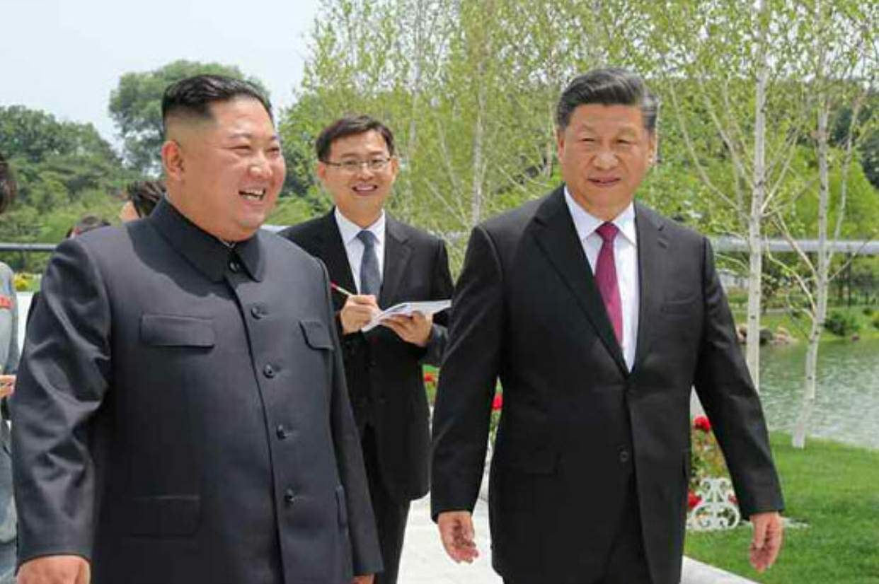 North Korean leader Kim Jong-un (left) and Chinese President Xi Jinping take a walk at the Kumsusan State Guesthouse in Pyongyang on June 21, 2019. (KCNA)