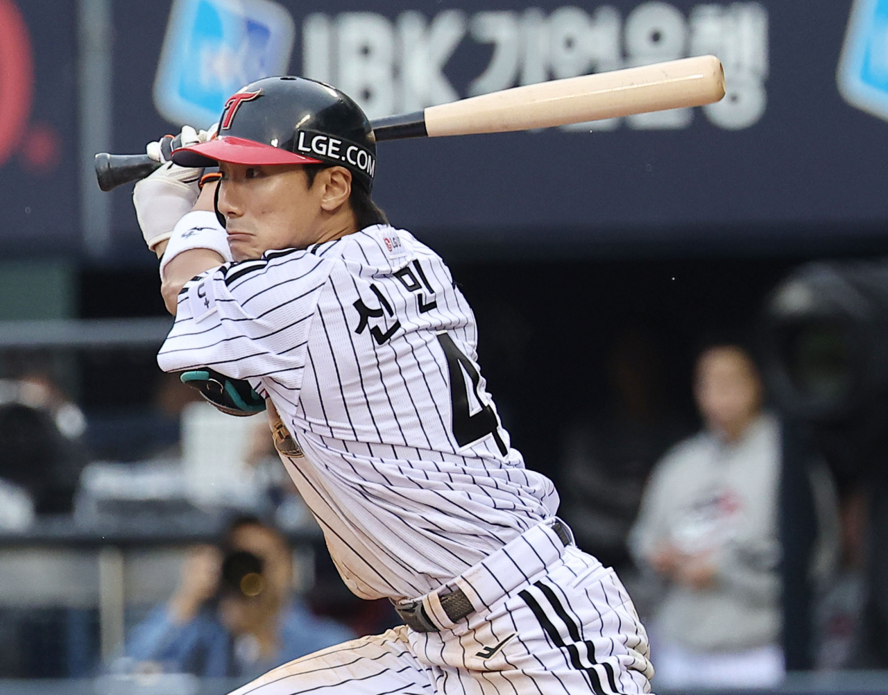 Shin Min-jae of the LG Twins tosses his bat after hitting a two-run single against the KT Wiz during Game 2 of the first round in the Korea Baseball Organization postseason at Jamsil Baseball Stadium in Seoul on Sunday. (Yonhap)