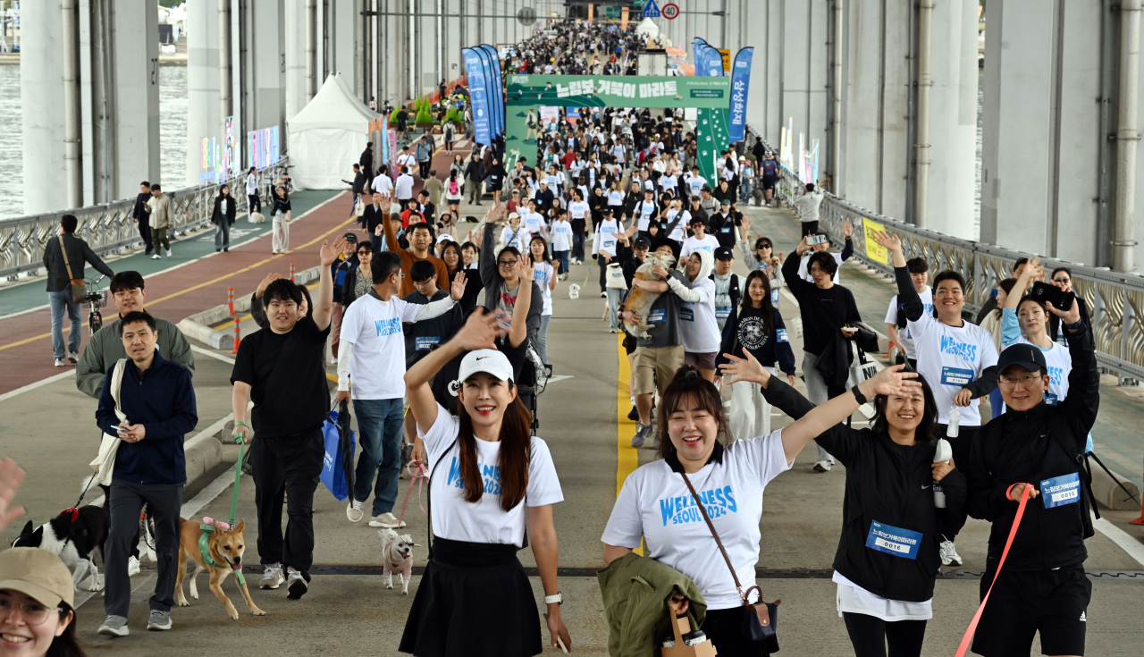 Participants of the Slow Marathon with Pets and their companion pets walk along the Jamsu Bridge -- a submersible bridge connecting Yongsan and Seocho -- on Sunday. (Park Hae-mook/The Korea Herald)