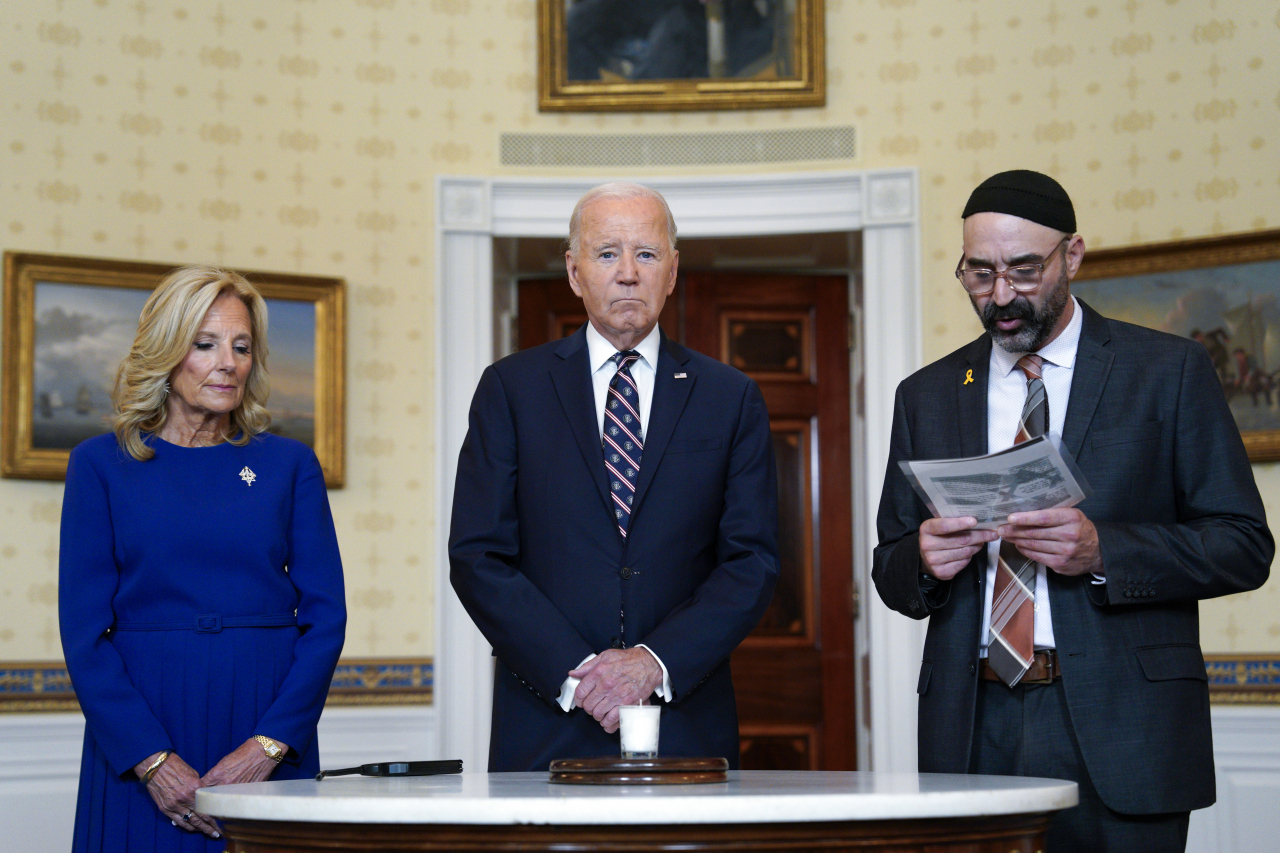 US President Joe Biden with first lady Jill Biden joined by a Rabbi participates in a yahrzeit candle lighting to mark one year since Hamas attacks on Israel in the Blue Room at the White House in Washington, DC, Monday. (EPA-Yonhap)