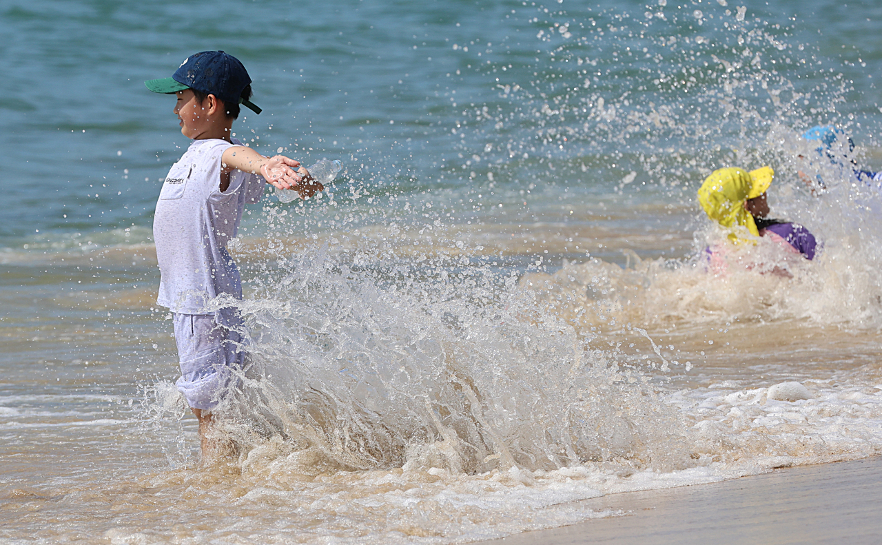 Children play in the water at Haeundae Beach in Busan on Sept. 19, when daytime temperatures reached as high as 34 degrees Celsius. (Yonhap)