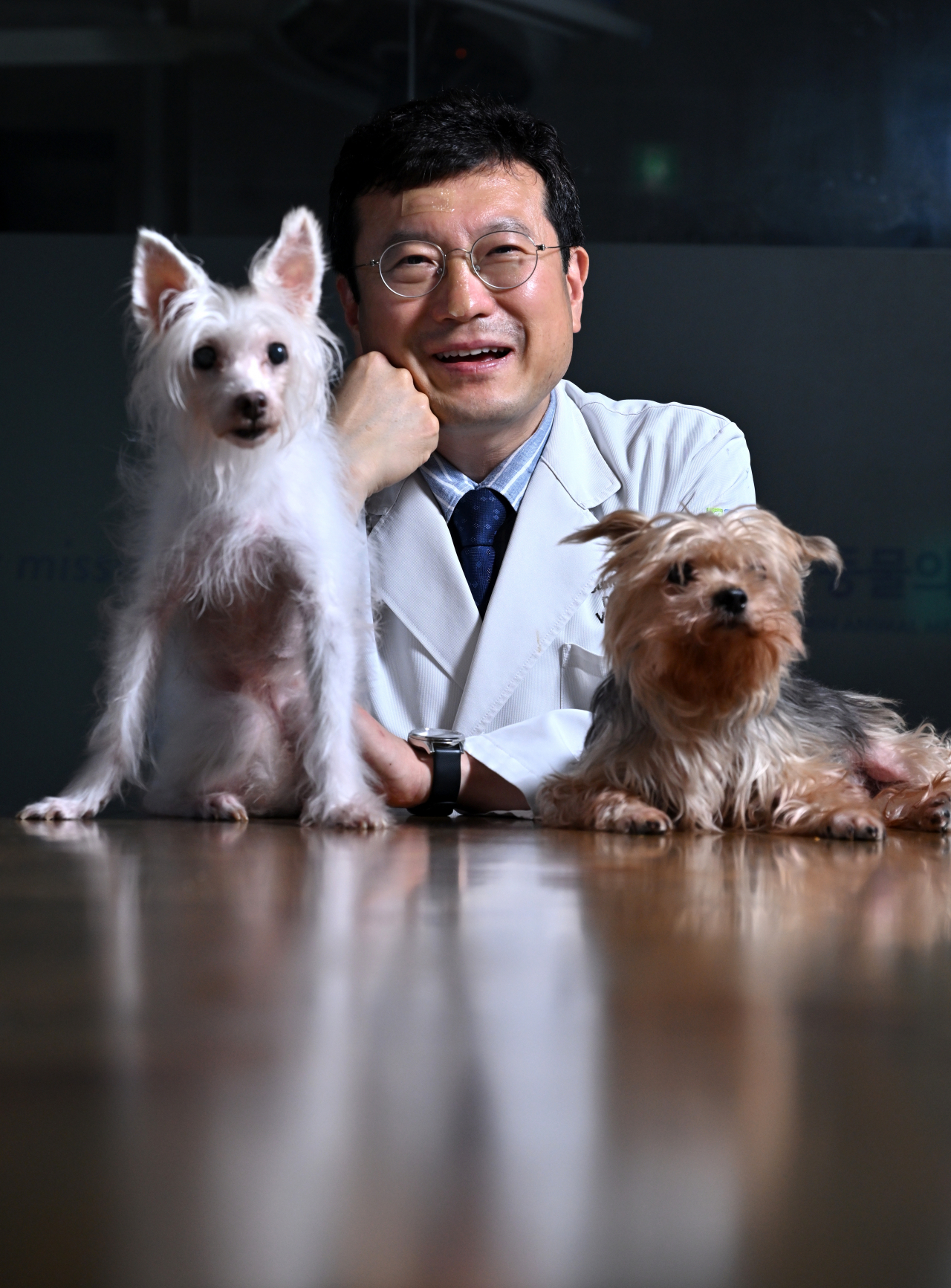 Veterinarian Choi Young-min poses with two rescue dogs he is raising at his clinic. (Im Se-jun/The Korea Herald)