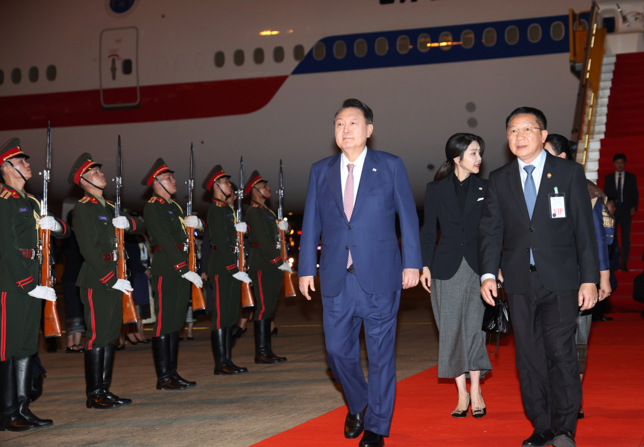 President Yoon Suk Yeol (third from right) and his wife Kim Keon Hee (second from right) disembarks from Air Force One at the Vientiane Wattay International Airport as he arrived in Vientiane, Laos on Wednesday. (Yonhap)