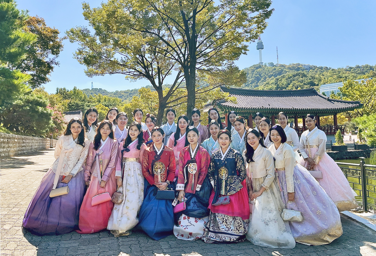 Korean Air's new foreign national crew members, adorned in Korean traditional attire, or hanbok, pose for a photo during the Dive into K-style training program. (Korean Air)