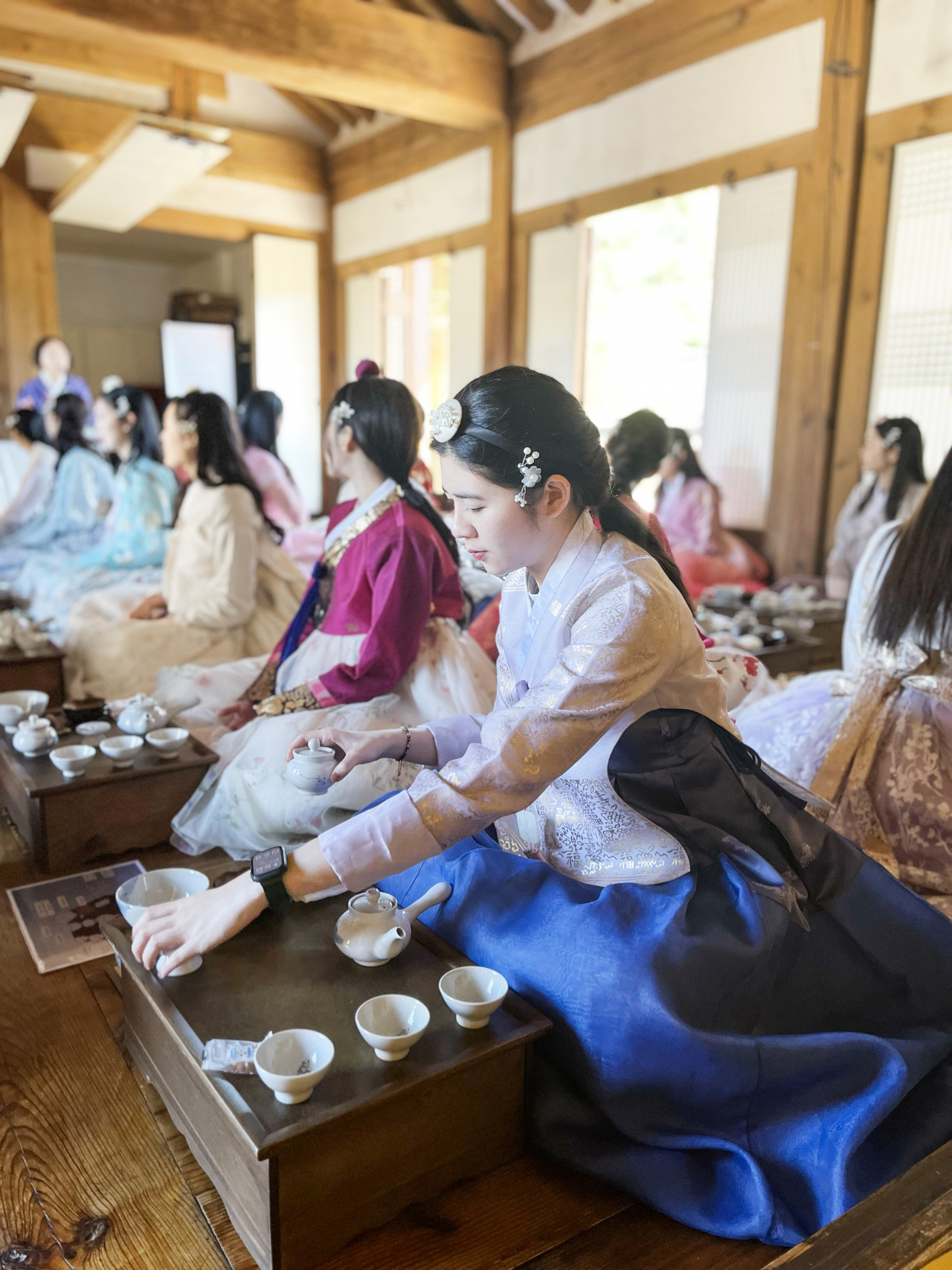 Korean Air's new foreign national crew members, adorned in Korean traditional attire, or hanbok, join a tea ceremony session during the Dive into K-style training program. (Korean Air)