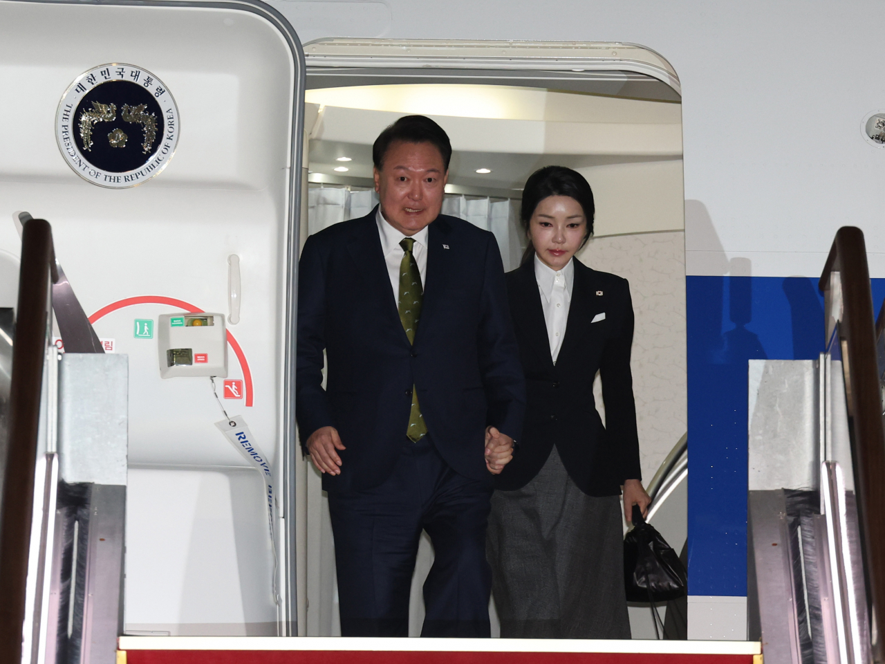 President Yoon Suk Yeol (left) and first lady Kim Keon Hee arrive at Seoul Air Base in Seongnam, just south of Seoul, Friday, after a three-nation Southeast Asia trip. (Yonhap)