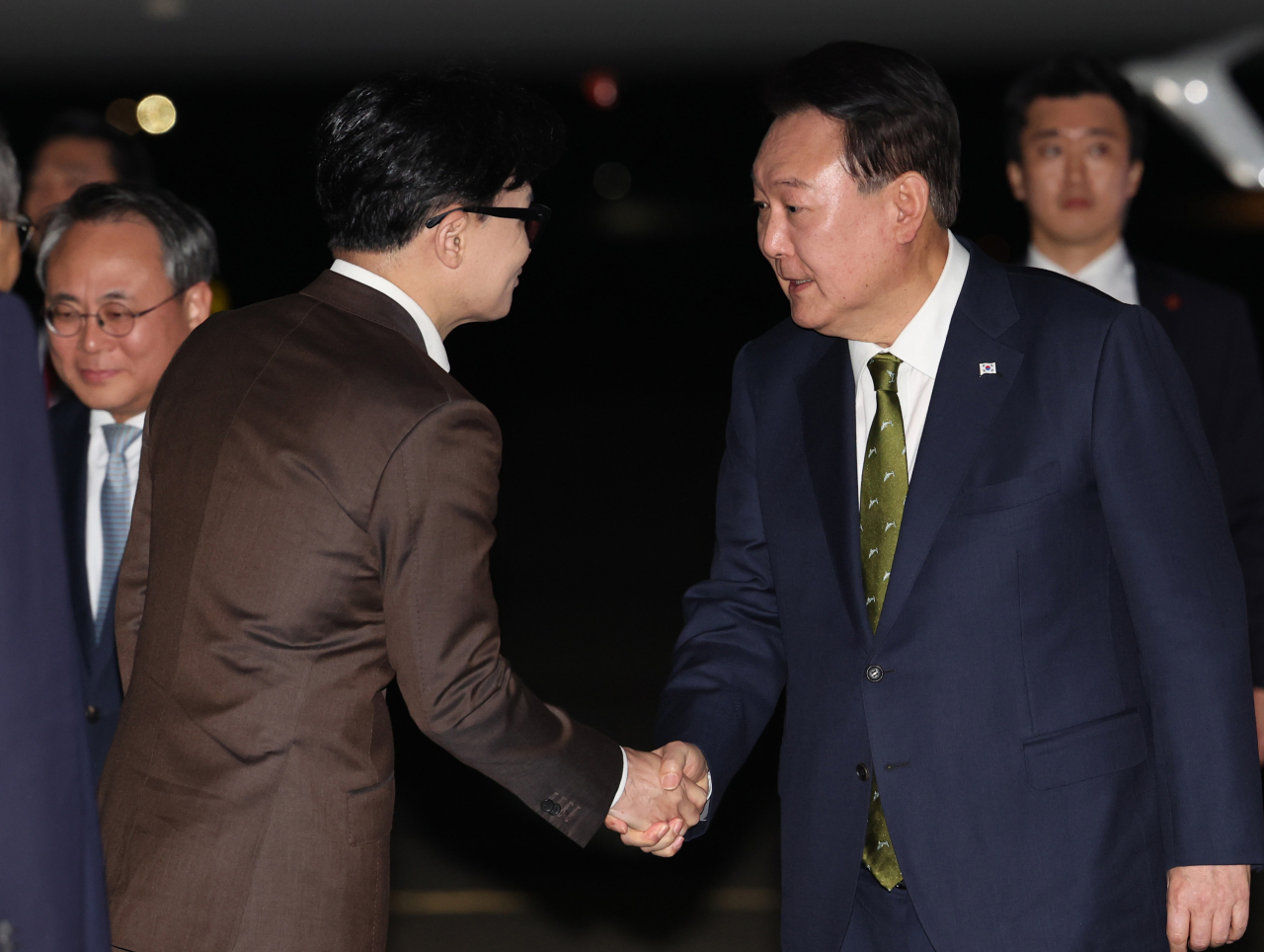 President Yoon Suk Yeol (right) shakes hands with People Power Party Chair Han Dong-hoon, as Yoon arrived at Seoul Air Base in Seongnam, Gyeonggi Province, after ending his weeklong trip to Southeast Asia on Friday. (Yonhap)