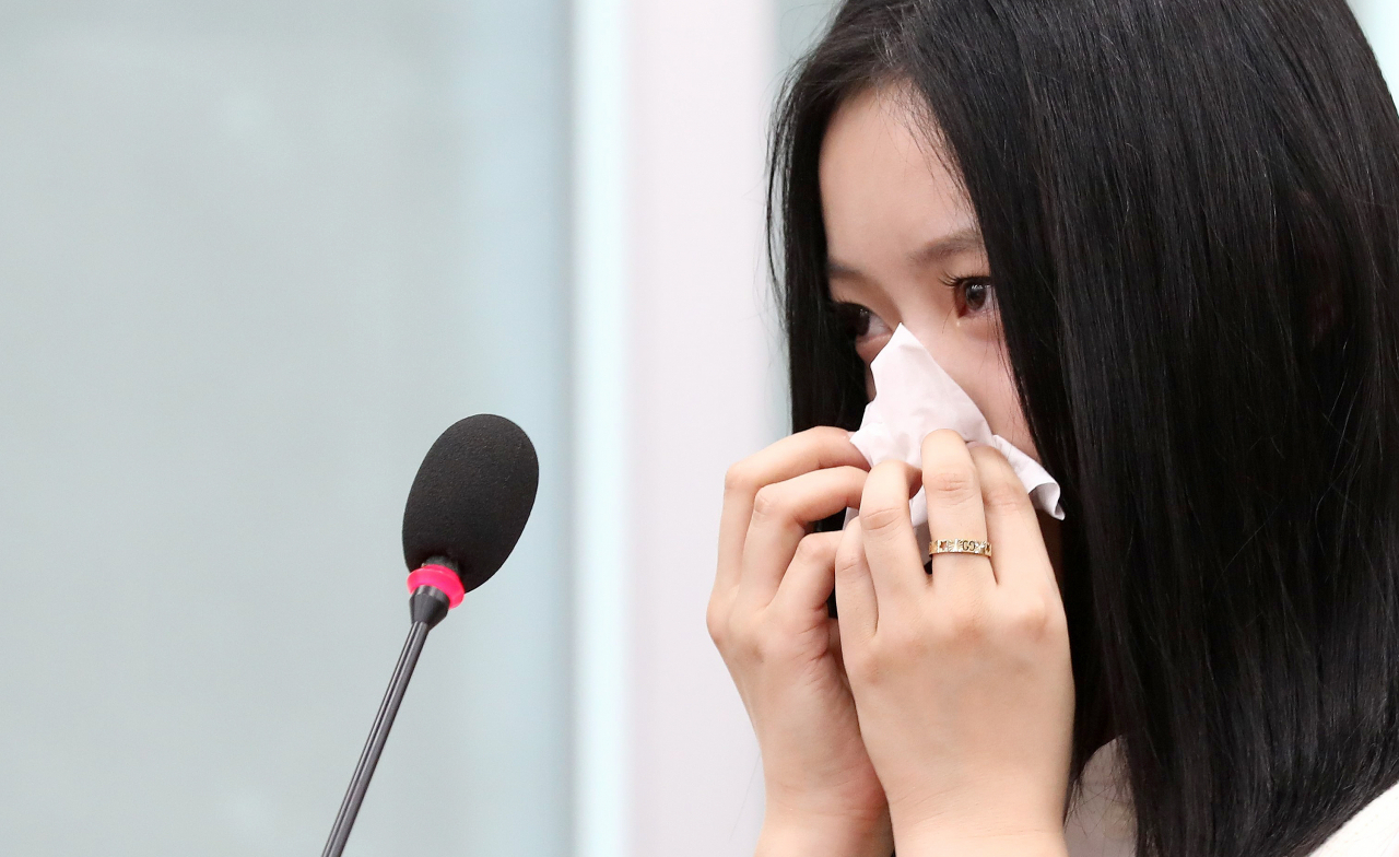 Hanni sheds tears as she speaks during a National Assembly audit in Seoul, Tuesday. (Newsis)