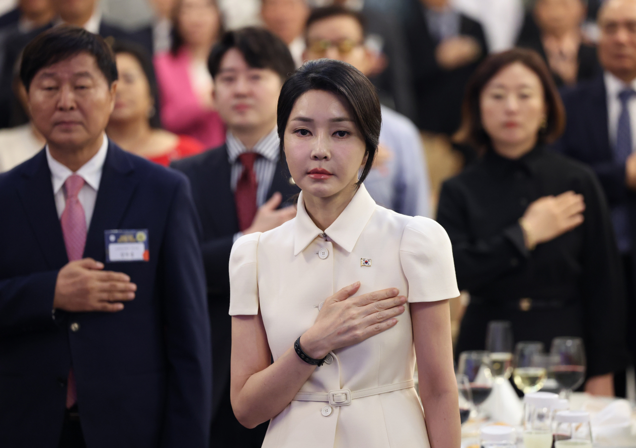 First lady Kim Keon Hee (center) salutes to the national flag at President Yoon Suk Yeol's meeting with overseas Koreans in Manila, the Philippines, held on the sidelines of his state visit to the country on Oct. 6. (Yonhap)