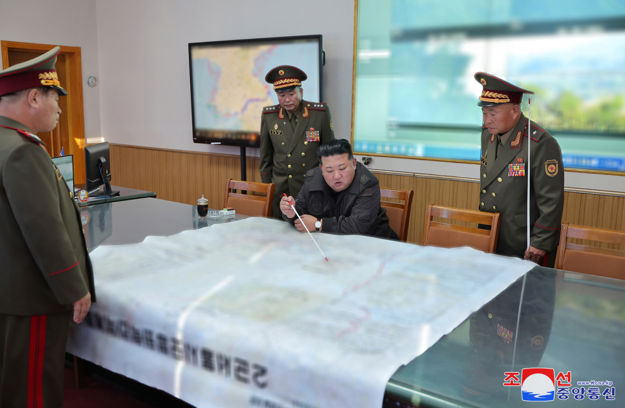 North Korean leader Kim Jong-un (center) points to a spot on a large map during his inspection of the 2nd Corps of the Korean People's Army on Thursday in this photo released by the North's official Korean Central News Agency(KCNA) the following day. (Yonhap)