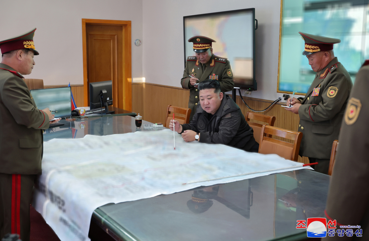 North Korean leader Kim Jong-un (center) points to a spot on a large map during his inspection of the 2nd Corps of the Korean People's Army on Thursday, in this photo released by the North's official Korean Central News Agency the following day. (Yonhap)