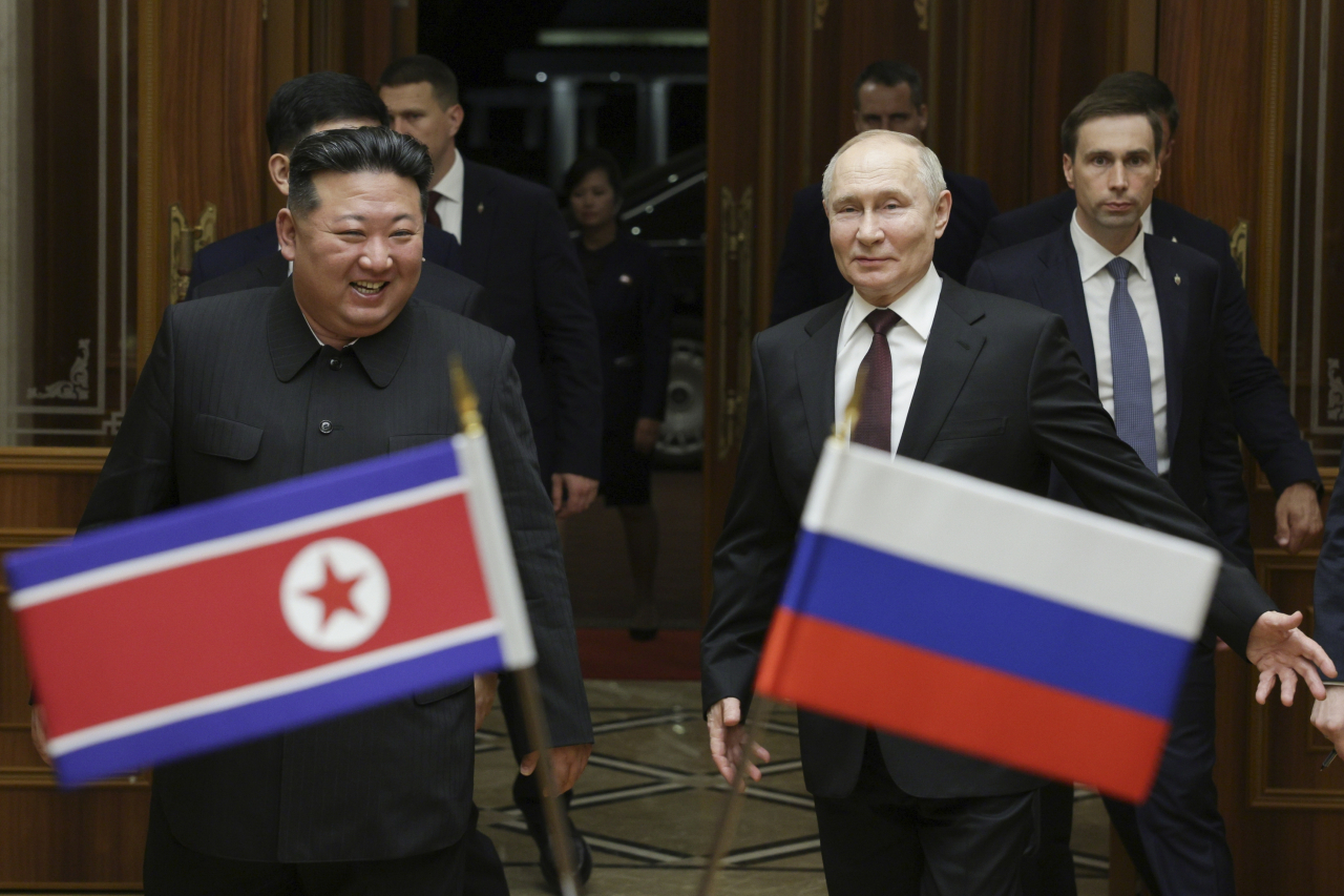 Russian President Vladimir Putin (right) and North Korea's leader Kim Jong Un smile during their meeting at the Pyongyang Sunan International Airport outside Pyongyang, North Korea, on June 19, 2024. (Kremlin Pool Photo via AP)