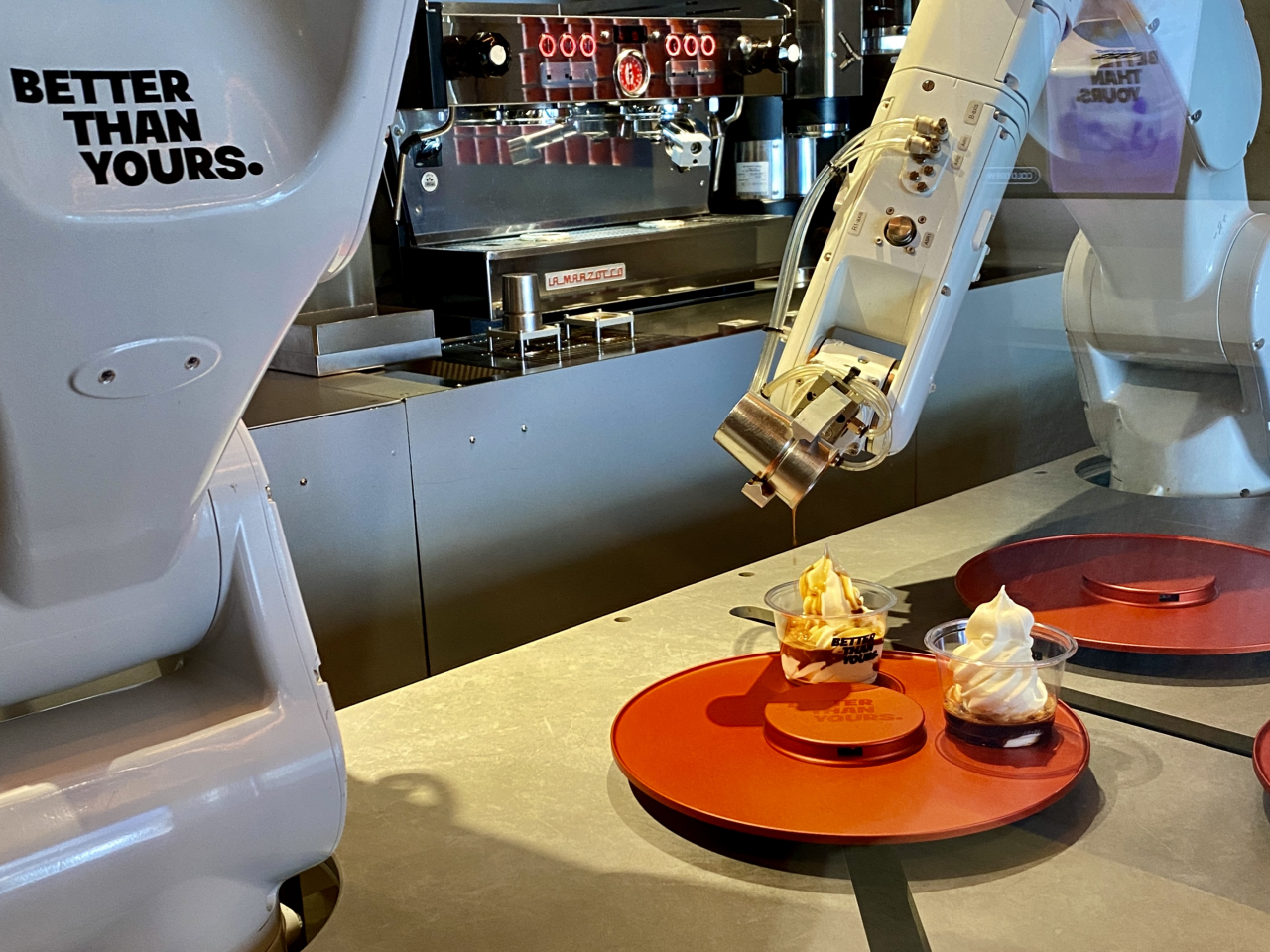 Barista robot Porty (right) pours an espresso shot over ice cream to make an affogato at Better Than Yours in Seongsu-dong, eastern Seoul, Wednesday. (Hwang Joo-young/The Korea Herald)