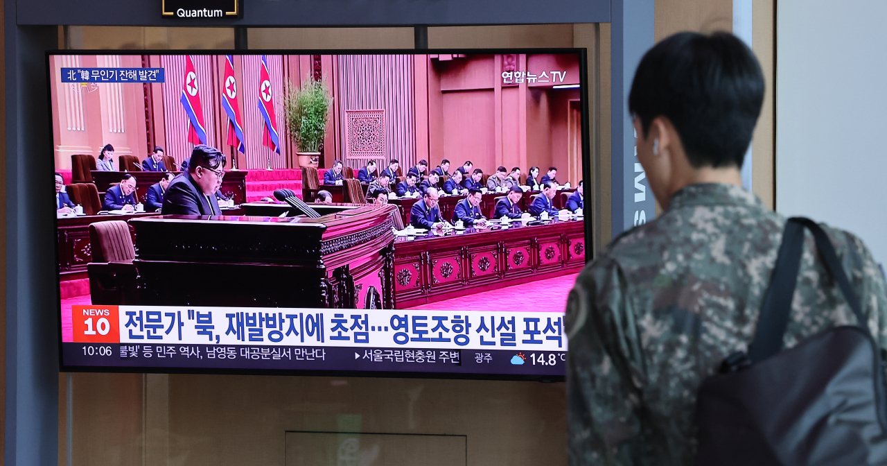 A Korean solider watches a news report on North Korea's deployment of troops to Russia at Seoul Station in central Seoul on Sunday. (Yonhap)