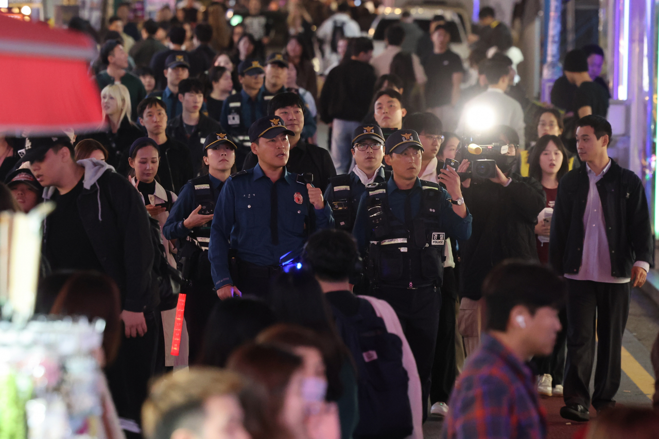 A group of police officers patrol a street near Hongik University Station in western Seoul on Saturday, the weekend before Halloween, to check for possible crowd safety risks. (Yonhap)