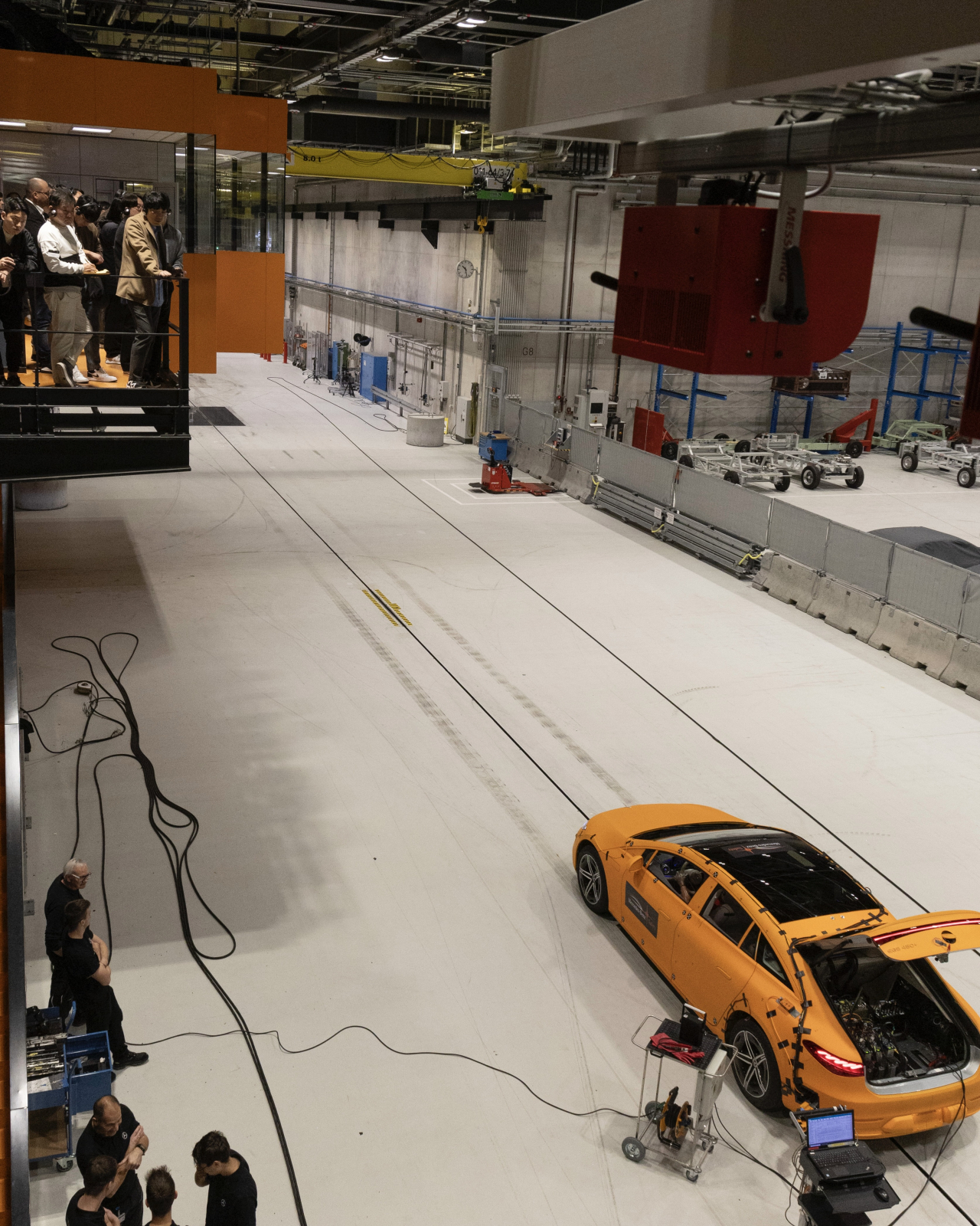 The Mercedes EQS is prepped for testing, with a group of reporters observing from a balcony above. (Mercedes-Benz)