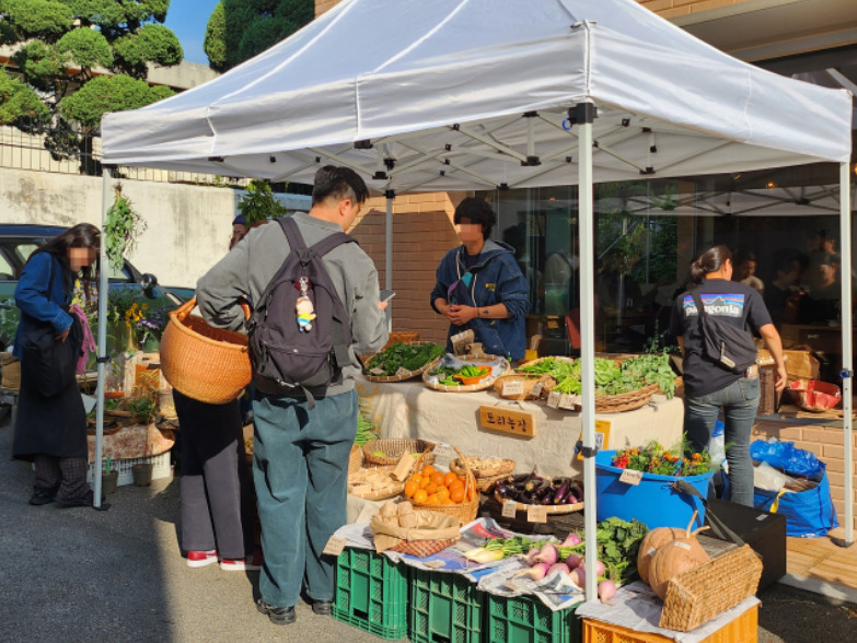 Neighborhood residents purchase vegetables at an open vegetable market held in front of the Collective Mine, Gungjeong-dong, Jongno-gu, Seoul, Oct. 30. (Lee Jung-youn/The Korea Herald)