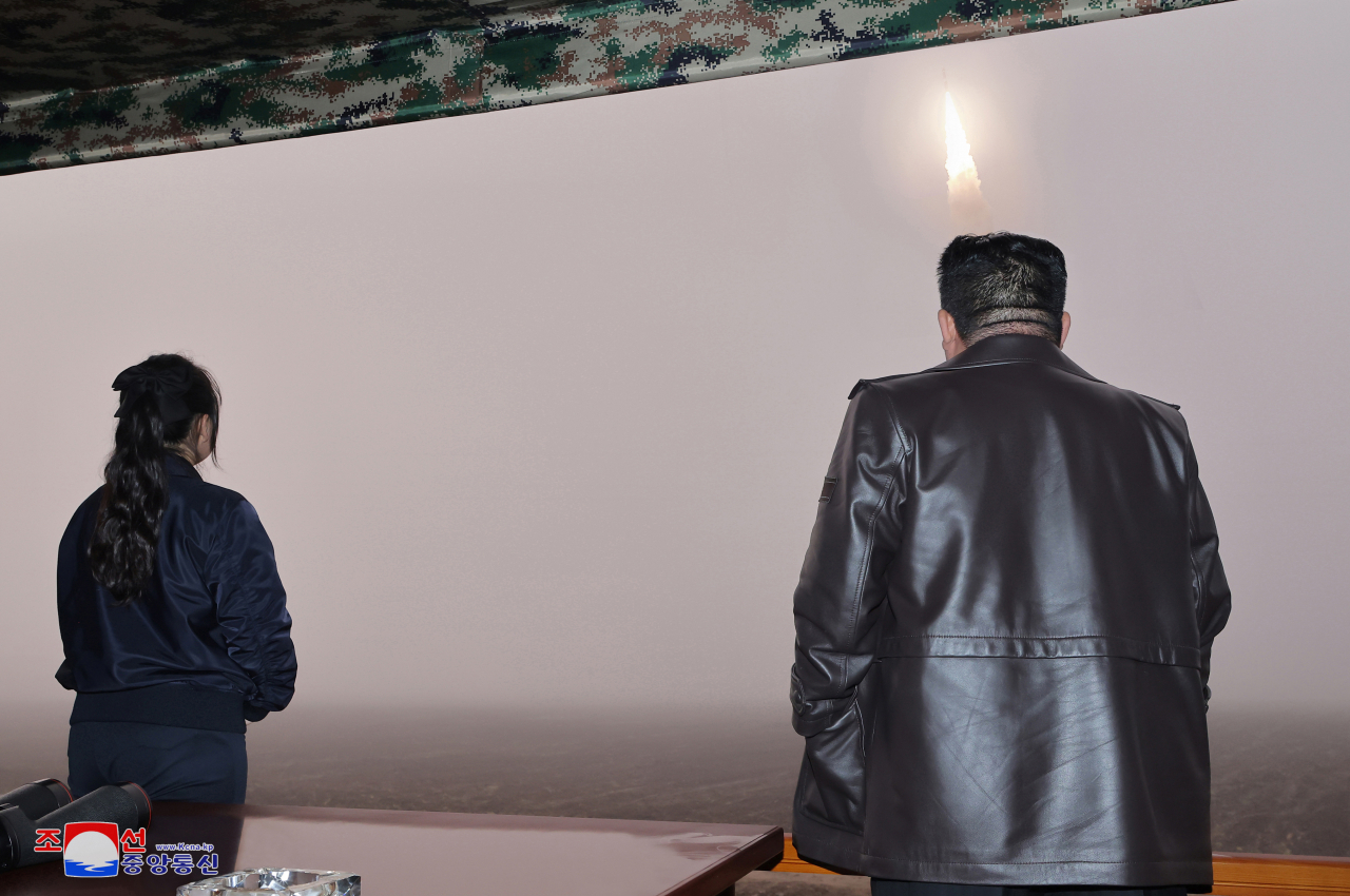 North Korean leader Kim Jong-un (right) and his daughter Kim Ju-ae observe the firing of the new Hwasong-19 intercontinental ballistic missile conducted on Thursday in this photo carried by North Korea's state-run Korean Central News Agency on Friday. (Yonhap)