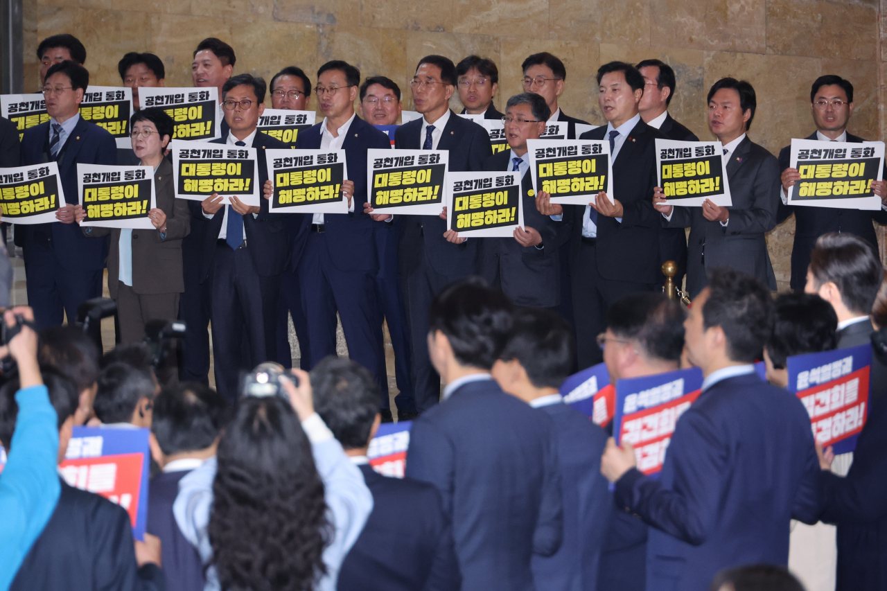 Democratic Party of Korea lawmakers hold placards calling for President Yoon Suk Yeol's explanation amid allegations of his election interference, at the National Assembly on Monday. (Yonhap)