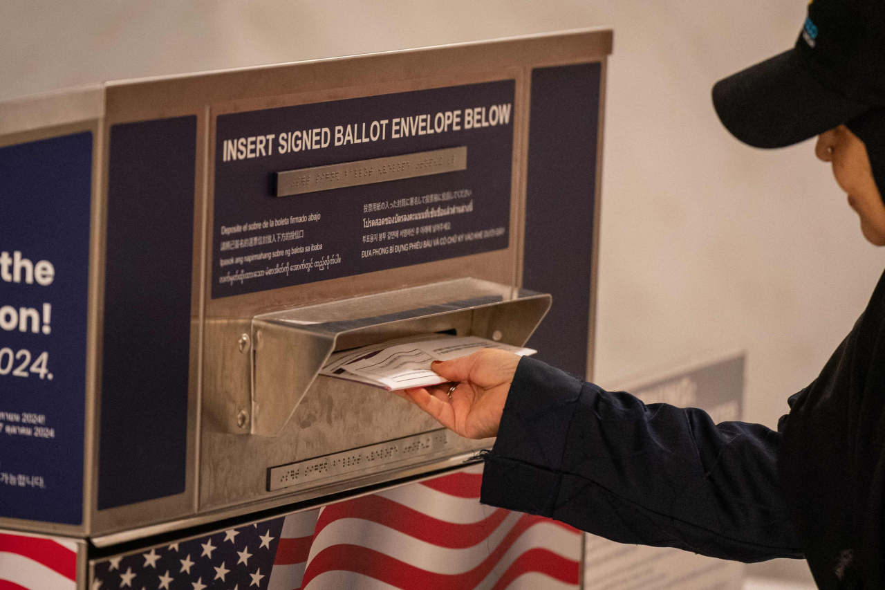 A voter drops off a ballot at an official ballot drop box at the San Francisco City Hall voting center on the final day of early voting ahead of Election Day, on Monday, in San Francisco, California. (AFP-Yonhap)