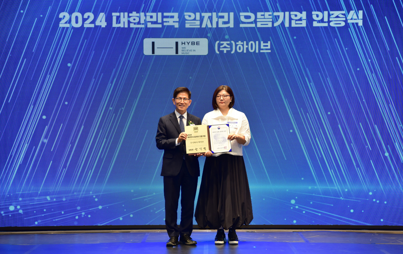 Minister of Employment and Labor Kim Moon-soo (left) poses with Hybe CHRO Kim Ju-young during a 