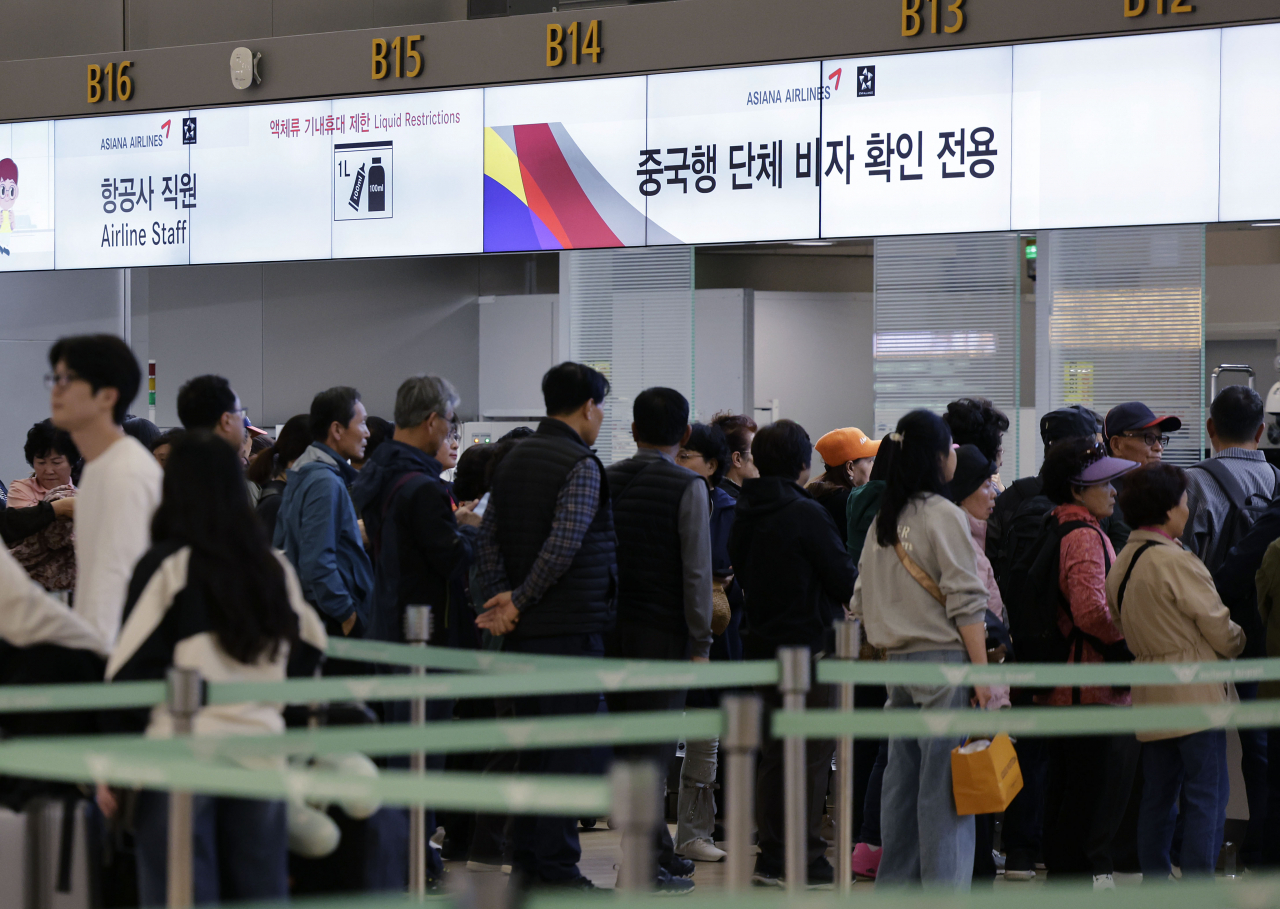 Passengers check in for flights to China at the Incheon International Airport on Sunday. (Newsis)