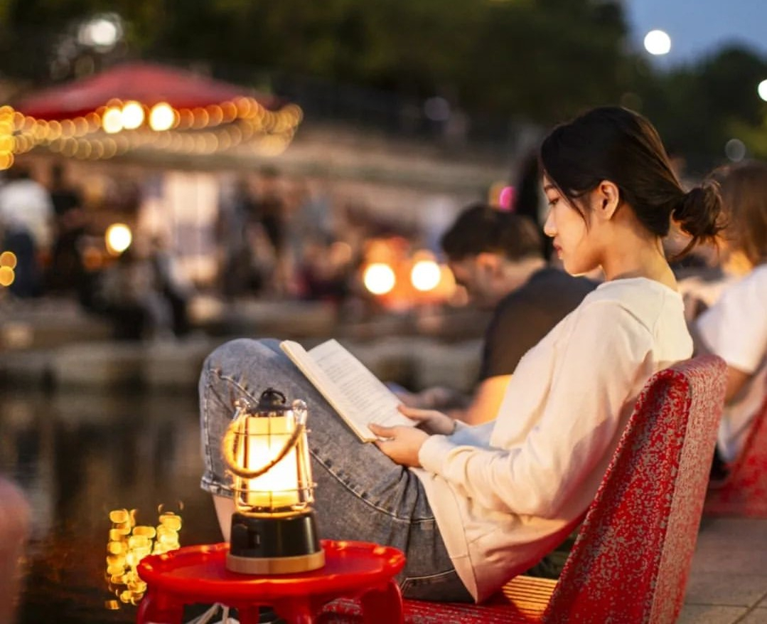 People read books at an outdoor library, which opened along the Cheonggye Stream. (Seoul Metropolitan Library)