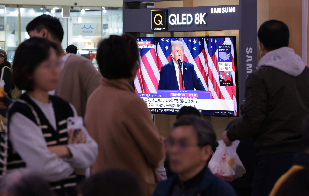 People watch a live broadcast of the US presidential election at Seoul Station in central Seoul on Wednesday. (Yonhap)