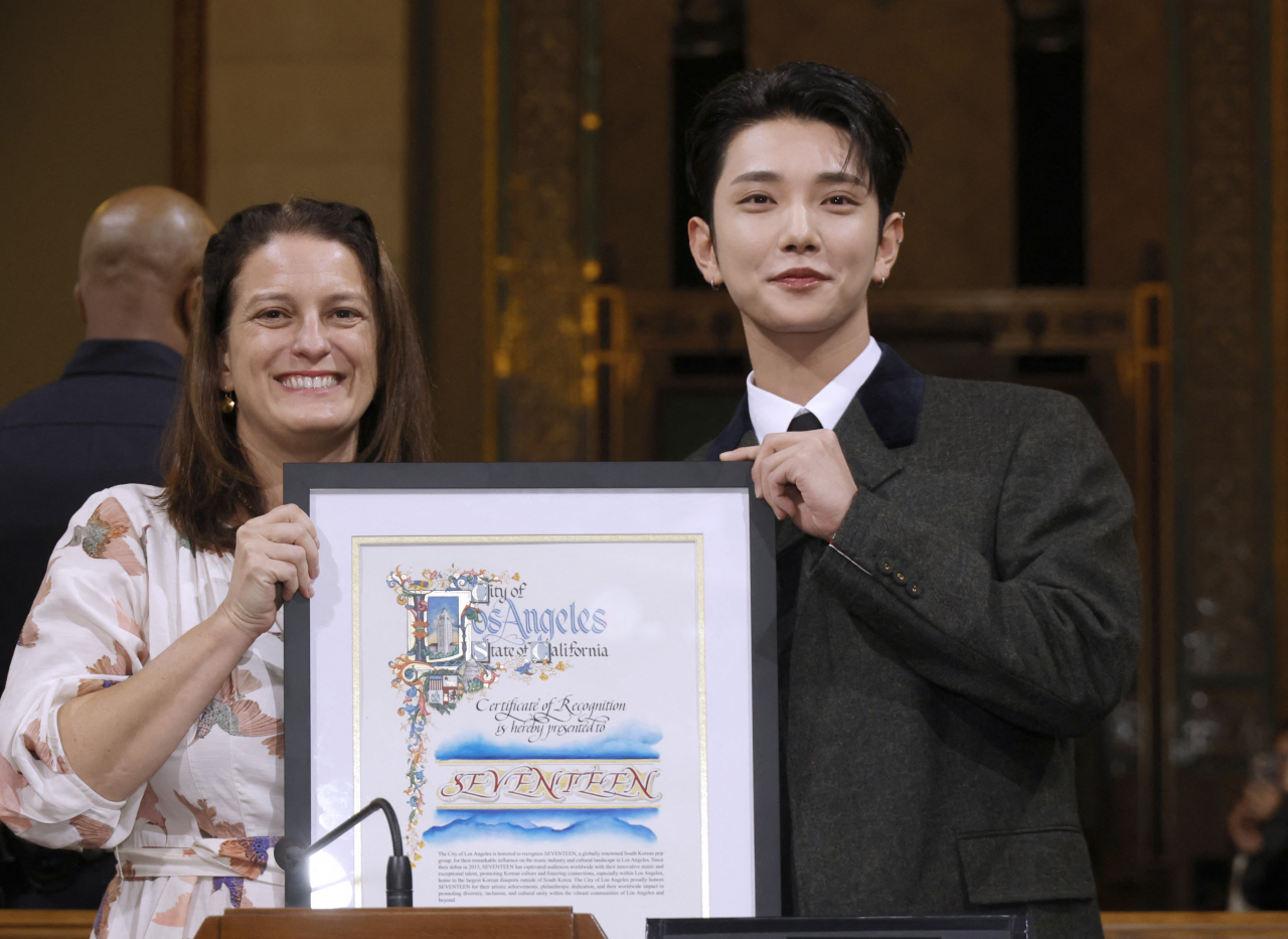 Joshua (right), a member of the K-pop group Seventeen, holds the certificate of appreciation presented by Katy Yaroslavsky of the Los Angeles City Council at Los Angeles City Hall on Saturday. (AFP-Yonhap)