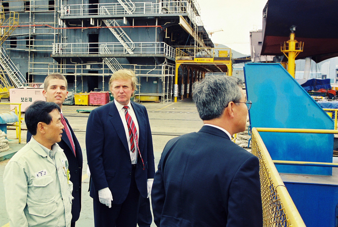 Donald Trump (second from right) looks around the Okpo shipyard of Daewoo Shipbuilding & Marine Engineering, now rebranded as Hanwha Ocean, in Geoje, South Gyeongsang Province, in 1998. (Yonhap)