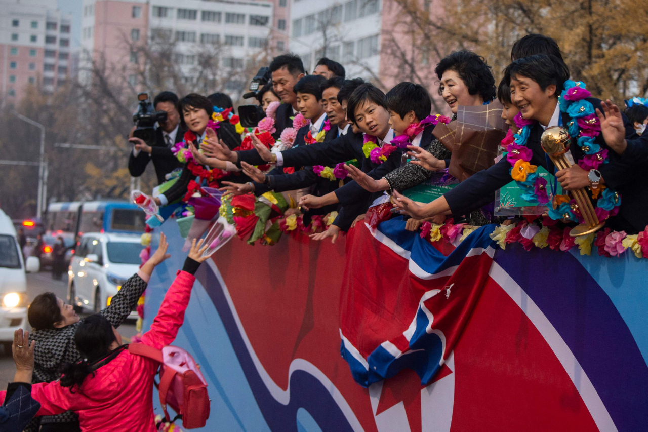 North Korean citizens welcome members of the North Korean women's under-17 football team on a street in Pyongyang on Saturday. (AFP-Yonhap)