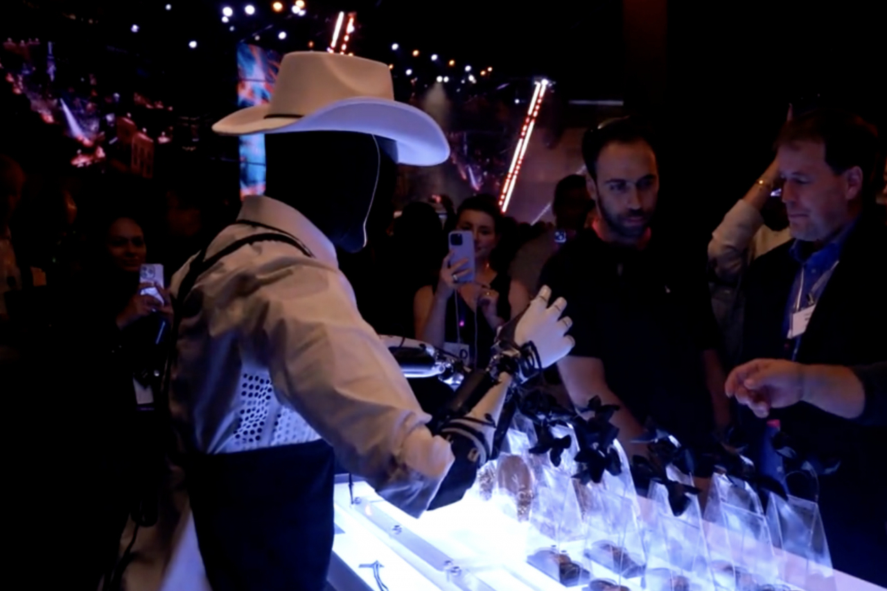 Tesla’s Optimus robot, wearing a cowboy hat, performed tasks like serving drinks at the company's “We, Robot” event on Oct. 10, though reports suggest much of the spectacle was achieved with human assistance. (Tesla)