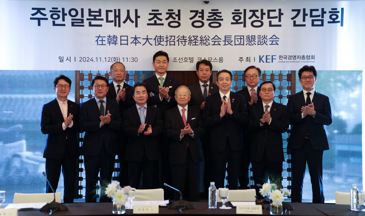 Korea Enterprises Federation Chairman Sohn Kyung-shik (fourth from left, front row), Japanese Ambassador to South Korea Koichi Mizushima (on Sohn’s left) and other business people from Korea pose during a roundtable meeting hosted by the business lobby at a Seoul hotel on Tuesday. Other participants include Kim Ju-nam, CEO of Hotel Lotte and Lotte Duty Free; Park Seung-hee, president of Samsung Electronics; Rhee Jang-han, chairman of Chong Kun Dang; Choi Hyun-kyu, CEO of Kolmar Korea; Lee Yong-ho, CEO of LX Pantos; and Kim Yeong-beom, CEO of Kolon Industries. (Newsis)