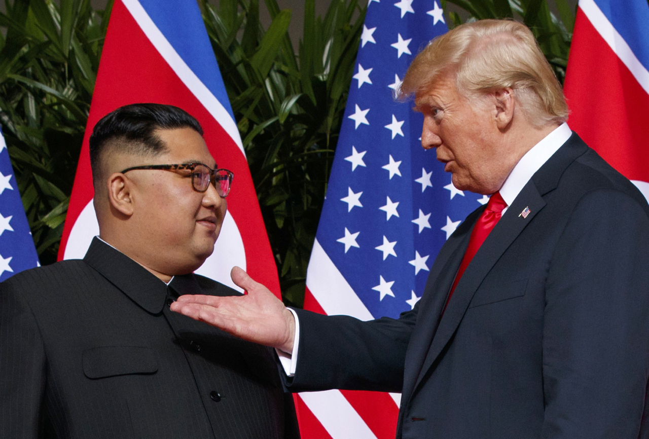 US President Donald Trump (right) meets with North Korean leader Kim Jong Un on Sentosa Island in Singapore, on June 12, 2018. (AP-Yonhap)