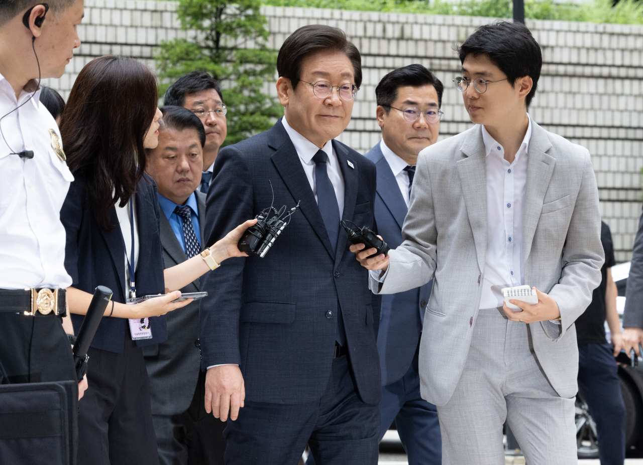 Lee Jae-myung (center), leader of the main opposition Democratic Party, is surrounded by reporters upon arriving at the Seoul Central District Court in the capital on Sept. 20, to attend the final hearing on his alleged election law violations for making false statements during his presidential campaign in 2021. (Yonhap)