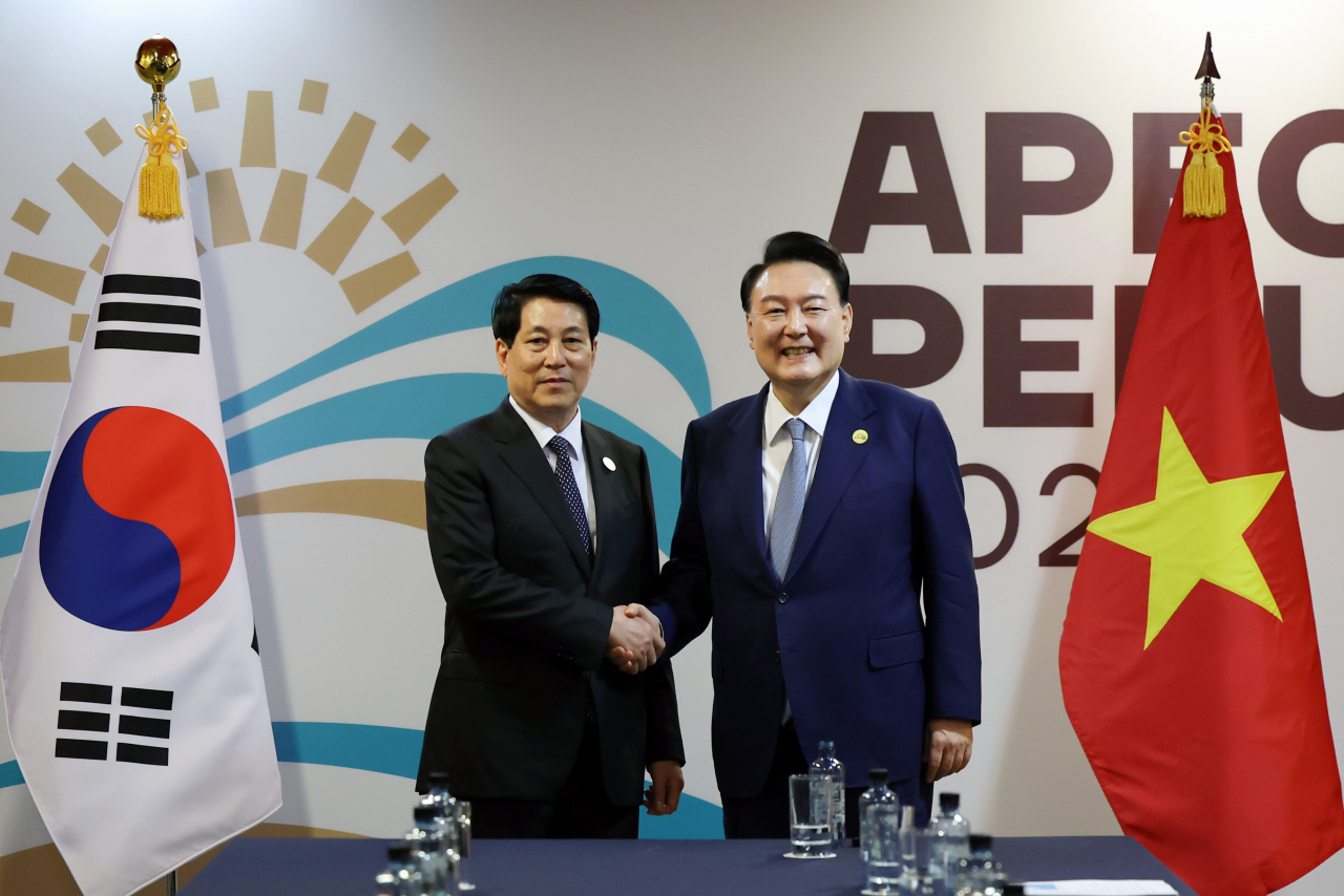 President Yoon Suk Yeol (right) shakes hands with Vietnamese President Luong Cuong ahead of their summit at the Lima Convention Center in Lima, Peru, on Saturday, on the sidelines of the Asia-Pacific Economic Cooperation summit. (Yonhap)