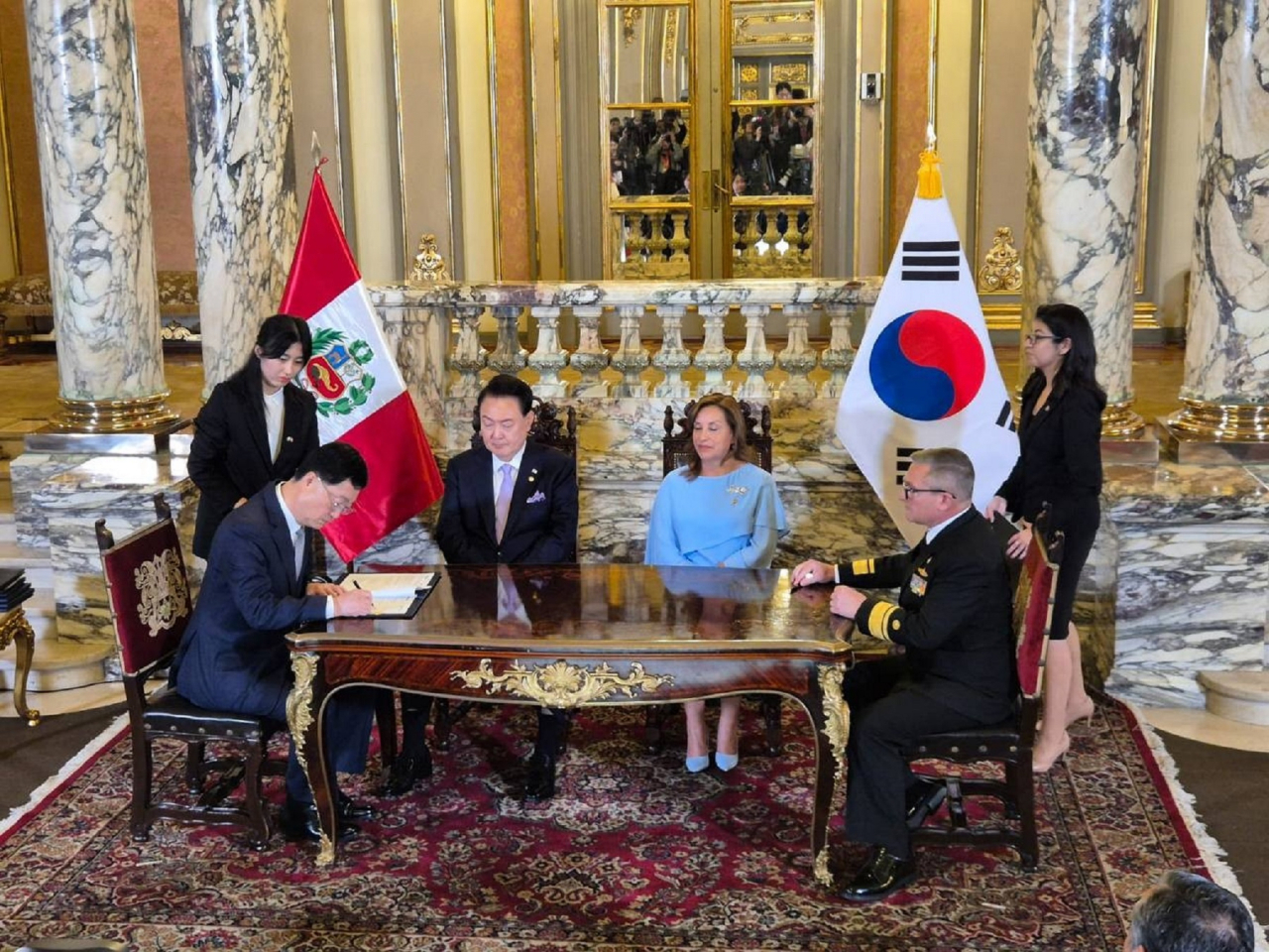 Joo Won-ho (far left), head of HD Hyundai Heavy Industries’ special ship business, and Cesar Benavides (far right), executive director of SIMA Peru, sign a memorandum of understanding at the Government Palace of Peru in Lima on Saturday, with President Yoon Suk Yeol (center left) and his Peruvian counterpart Dina Boluarte (center right) in attendance. (Presidential Office)