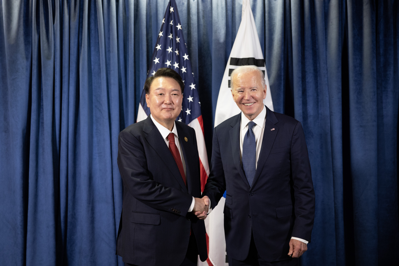 President Yoon Suk Yeol (left) shakes hands with US President Joe Biden during their meeting at the Lima Convention Center in Lima, Peru, on Saturday, on the sidelines of the Asia-Pacific Economic Cooperation summit. (Pool photo via Yonhap)