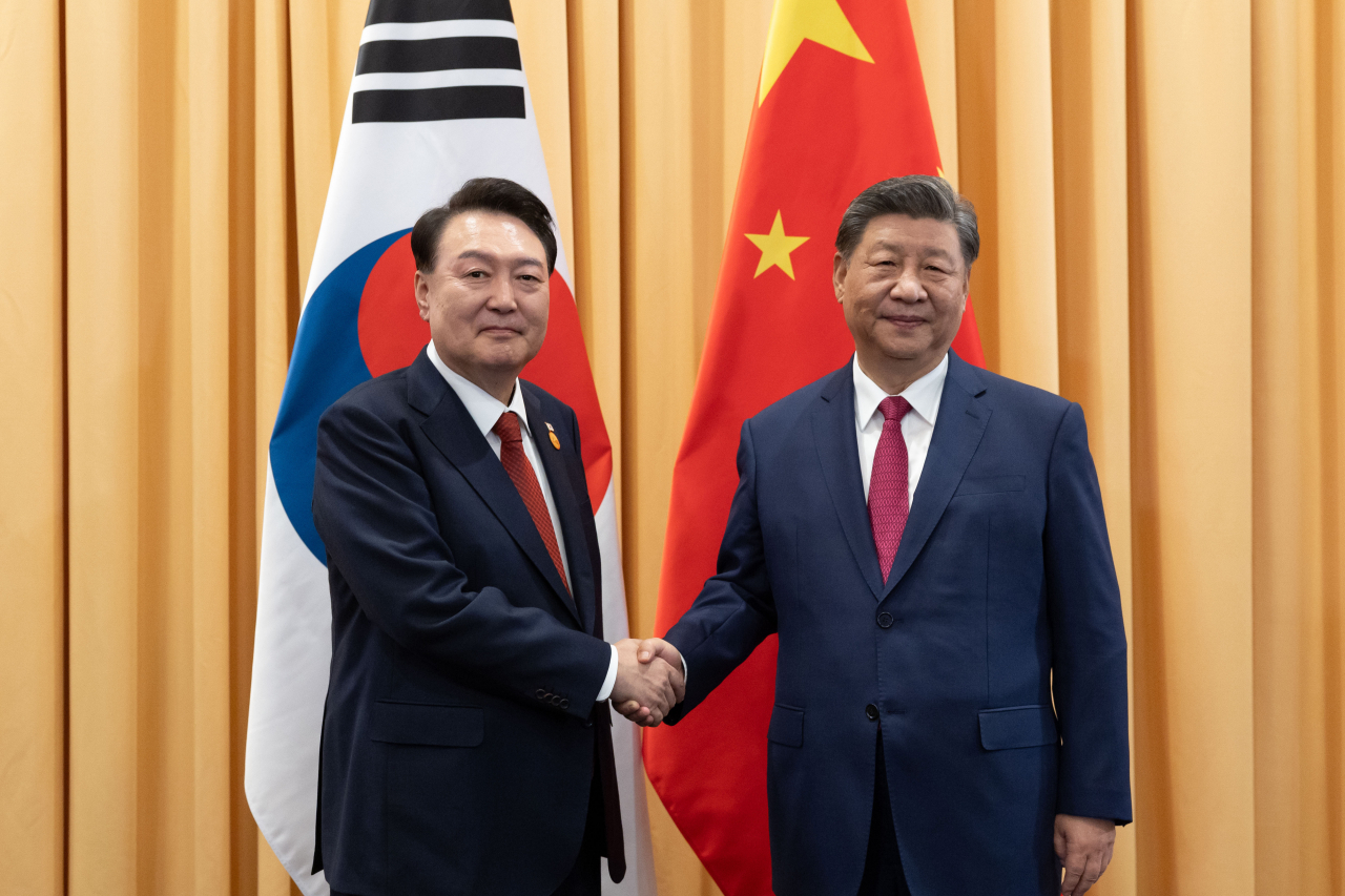 President Yoon Suk Yeol (left) shakes hands with Chinese President Xi Jinping during their meeting in Lima, Peru, on Friday, on the sidelines of the Asia-Pacific Economic Cooperation summit. (Yonhap)