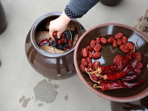 Jujubes, chile peppers and other ingredients are added to a jar of fermented jang. (Cultural Heritage Administration)