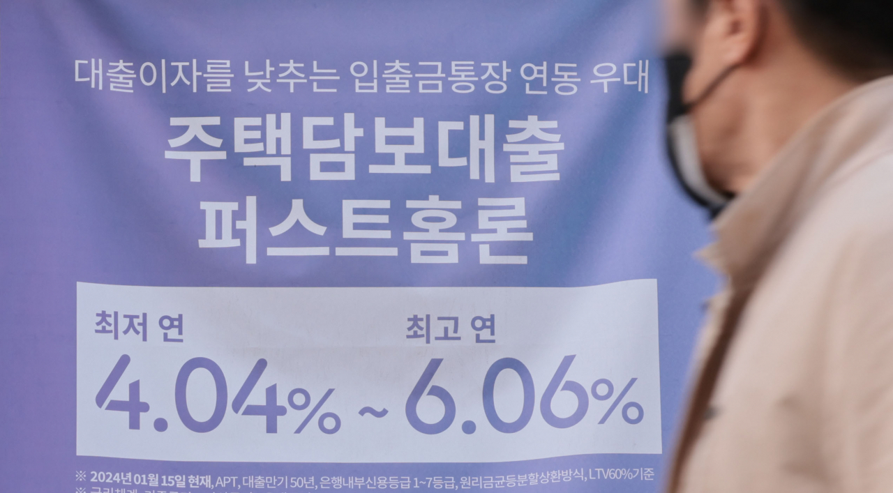 A man walks by a banner promoting a loan product of a Seoul-based bank on Tuesday. (Yonhap)