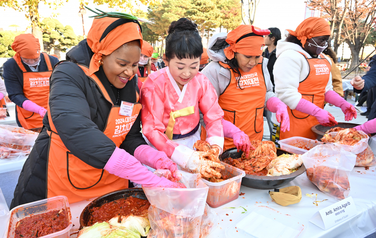 South African Ambassador Sindiswa Mququ (left), Sudan Ambassador Amira Agarib (second from right) and Kenya Ambassador Emmy Jerono Kipsoi (right) make kimchi in the 2024 Korea Kimchi Grand Festival in front of the National Assembly Communication Building in Yeouido, Seoul, Friday. (Im Se-jun/The Korea Herald)