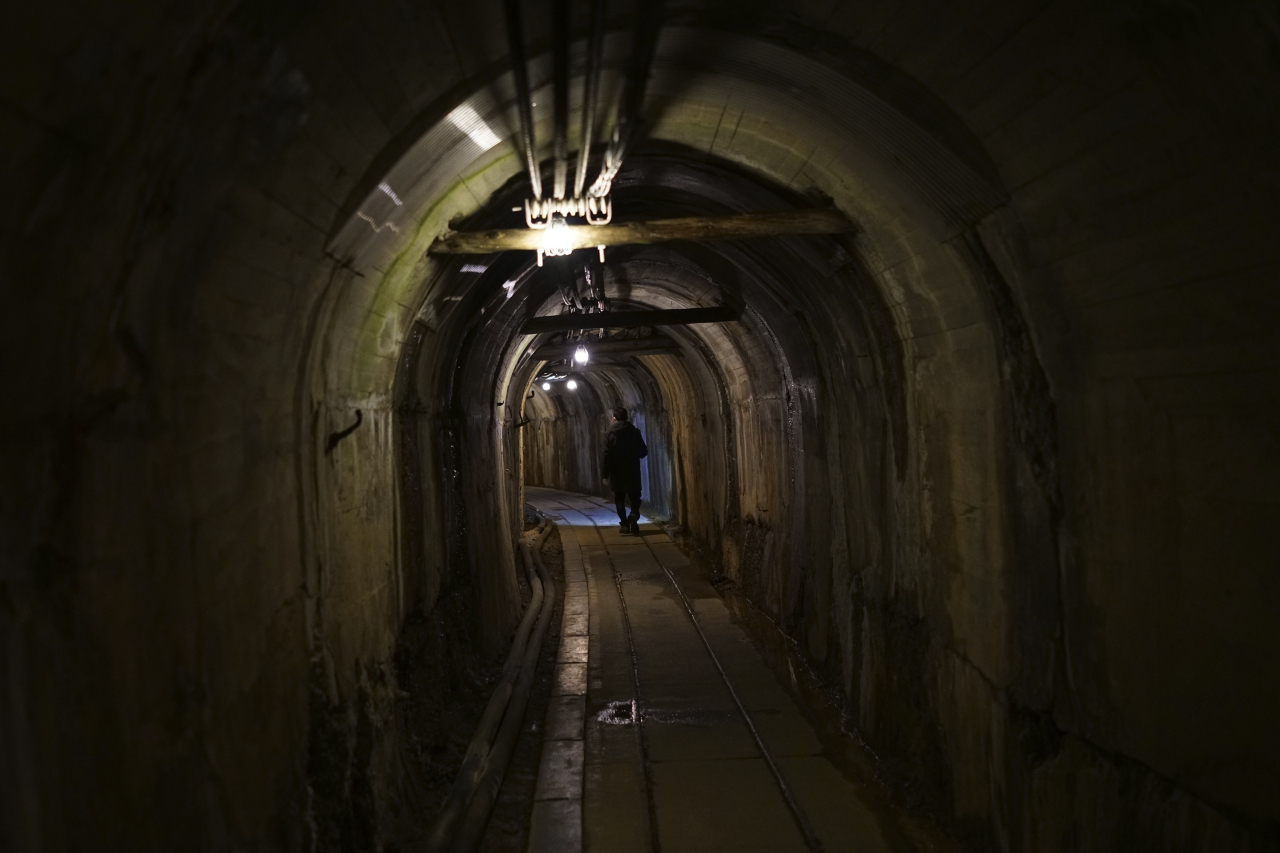 A staff walks through a tunnel at Sado Kinzan Gold Mine historic site in Sado, Niigata prefecture, Japan, Sunday. (AP)