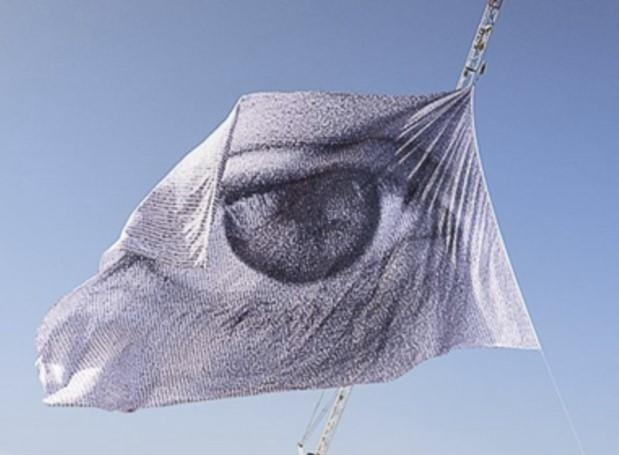 A flag featuring an eye, created by Greenpeace, is raised near BEXCO as the fifth session of the United Nations Intergovernmental Negotiating Committee on Plastic Pollution opens on Monday. (Greenpeace)