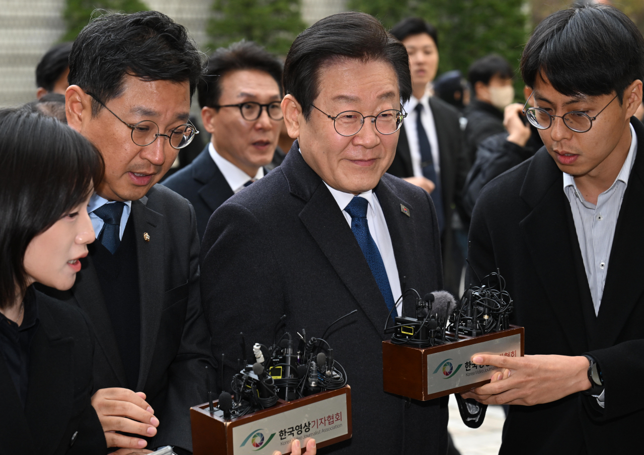 Lee Jae-myung (center), the leader of the main opposition Democratic Party, arrives at the Seoul Central District Court ahead of his sentencing on charges of subornation of perjury, on Monday. (Yonhap)