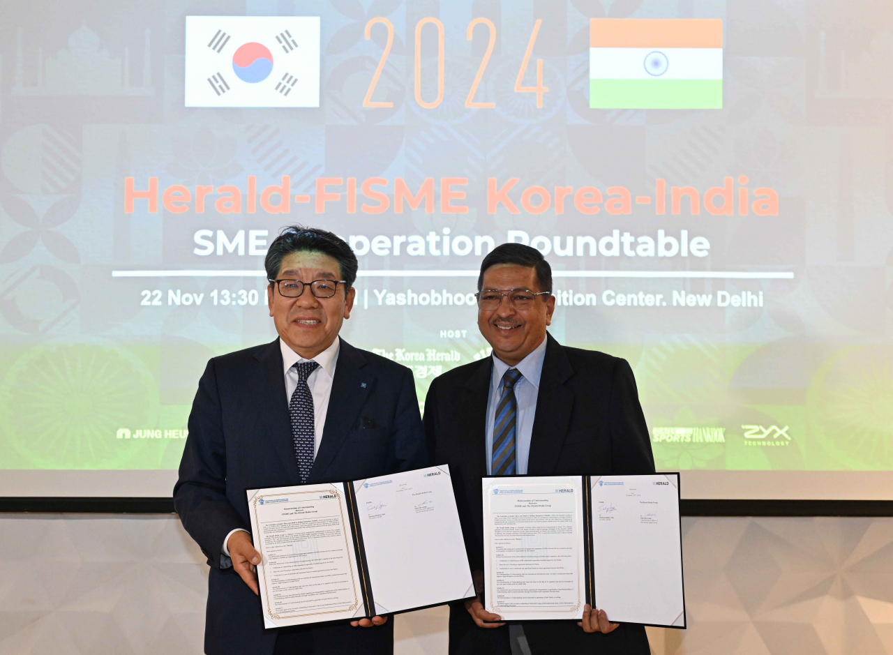 Herald Media Group CEO Choi Jin-young (left) and Sandeep Kishore Jain, president of the Federation of Indian Micro and Small & Medium Enterprises, pose after signing a memorandum of understanding at the Yashobhoomi convention center in Dwarka, New Delhi, on Friday. (Park Hae-mook/ The Korea Herald)