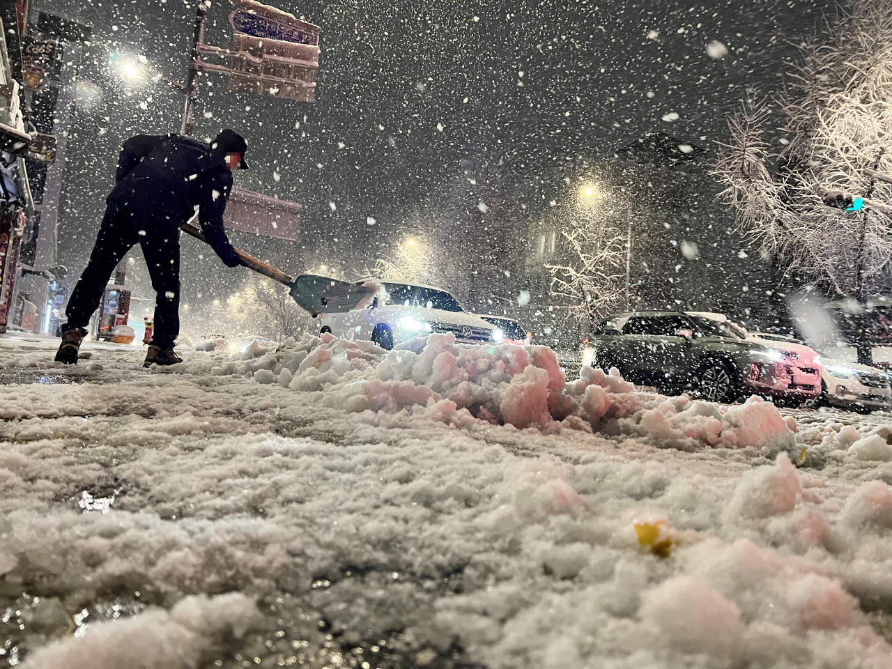 A citizen clears snow near Gyeongbokgung Station in Seoul on Wednesday. (Yonhap)