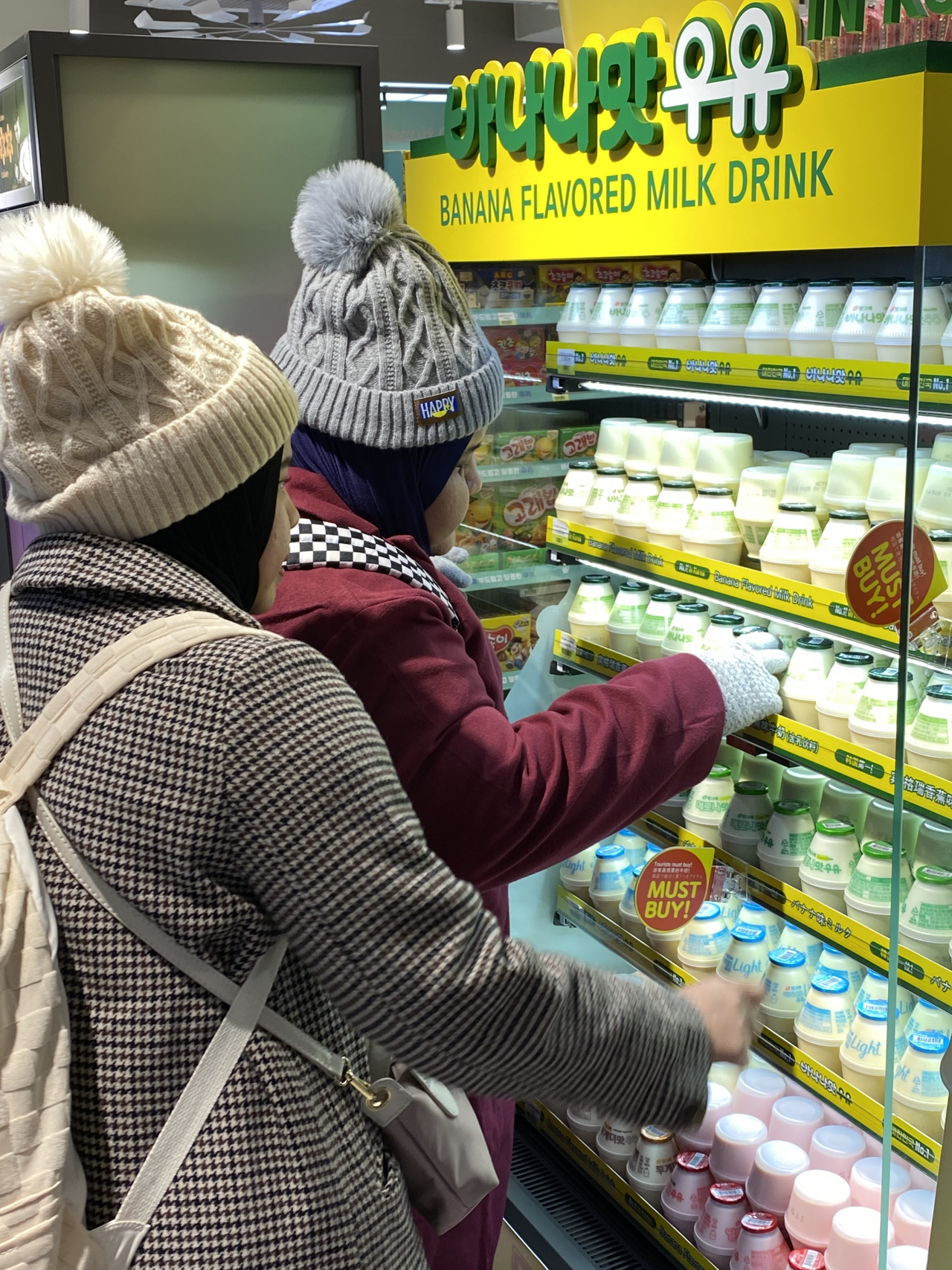 Visitors browse Binggrae's flavored milk display in the newly opened K-food-themed CU convenience store in Myeong-dong, central Seoul, Tuesday. (Hwang Joo-young/The Korea Herald)